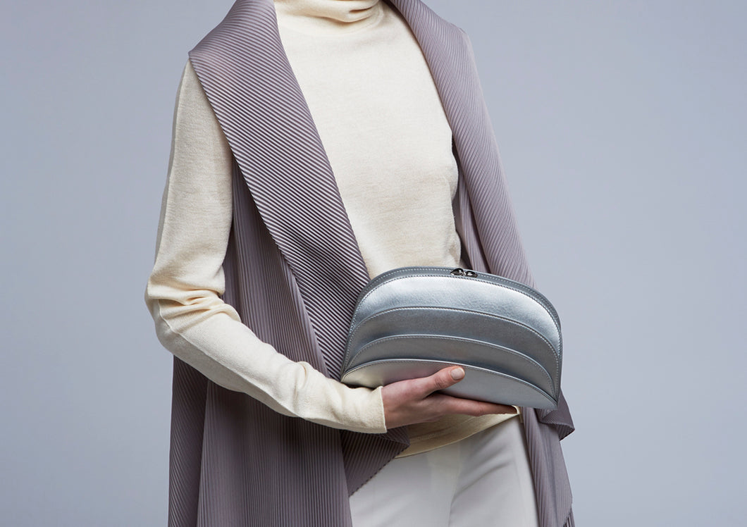 The model wears a Gabo Guzzo Millefoglie C clutch bag in silver calfskin and palladium plated hardware. One-of-a-kind creation embellished with fine jewellery and handcrafted in Italy.