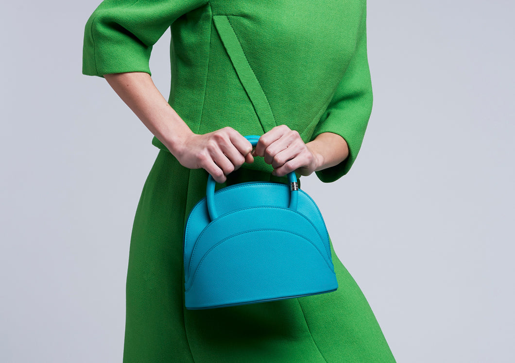 The model wears a Gabo Guzzo Millefoglie M mini handbag in Tropea blue calfskin and palladium plated hardware. One-of-a-kind creation embellished with fine jewellery and handcrafted in Italy.